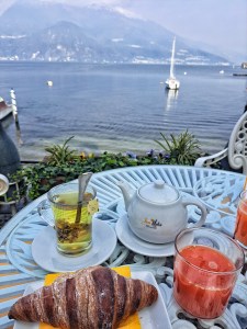 I am Sofia Lena Perissinotto, I am a blogger, content creator. In this article, I talk about Varenna, a lovely village at the Como Lake. In this photo, I am sitting in one of the cafes along the lake shore called Bar Il Molo. A perfect place to have something to eat while admiring the view in front of me!