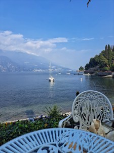I am Sofia Lena Perissinotto, I am a blogger, content creator. In this article, I talk about Varenna, a lovely village at the Como Lake. In this photo, I am sitting in one of the cafes along the lake shore called Bar Il Molo. A perfect place to have something to eat while admiring the view in front of me!