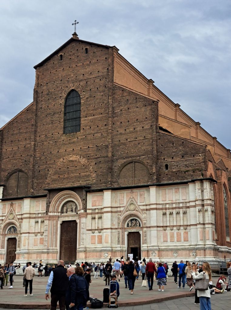 I'm Sofia Lena Perissinotto. I am a travel blogger. In this blog post I talk about Bologna, a stunning, historical city located in the Italian region Emilia-Romagna. The photo is taken in the stunning and most famous piazza of Bologna: Piazza Maggiore. The photo shows the Basilica di San Petronio.