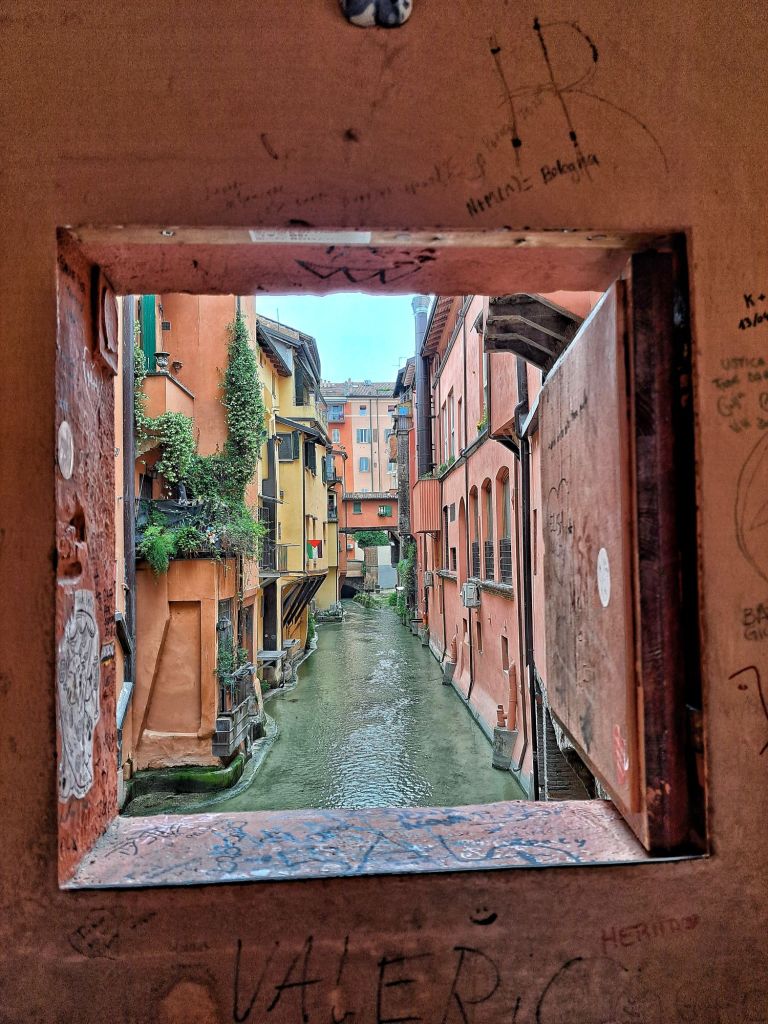 I'm Sofia Lena Perissinotto. I am a travel blogger. In this blog post I talk about Bologna, a stunning, historical city located in the Italian region Emilia-Romagna. In this photo, you can see one of Bologna's oldest and picturesque canals. It's taken from La Finestrella di Bologna, one of Bologna's hidden gems!