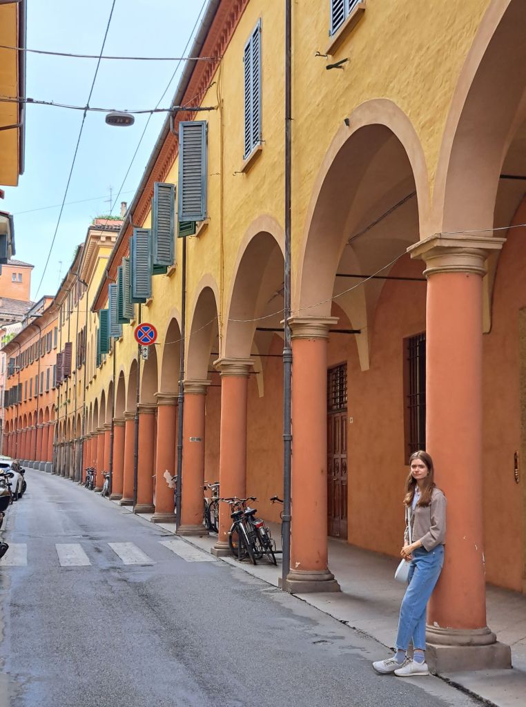 I'm Sofia Lena Perissinotto. I am a travel blogger. In this blog post I talk about Bologna, a stunning, historical city located in the Italian region Emilia-Romagna. In this photo you can see some stunning porticoes!