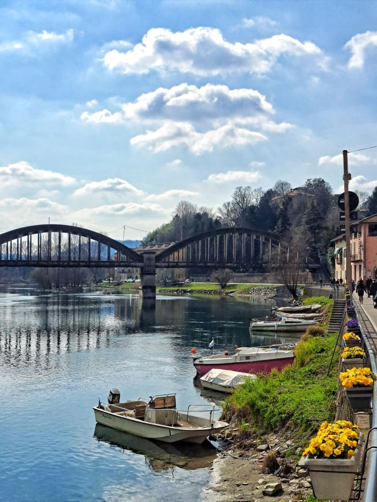 I am Sofia Lena Perissinotto, I am a travel blogger. In this blog post I write about the charming, picturesque town of Brivio in the province of Lecco, Lombardy region, Italy. I also write about some of my favourite cafes, the famous old bridge and the Northern Adda Park. This photo mainly shows a picturesque Brivio photo with the Old Bridge.