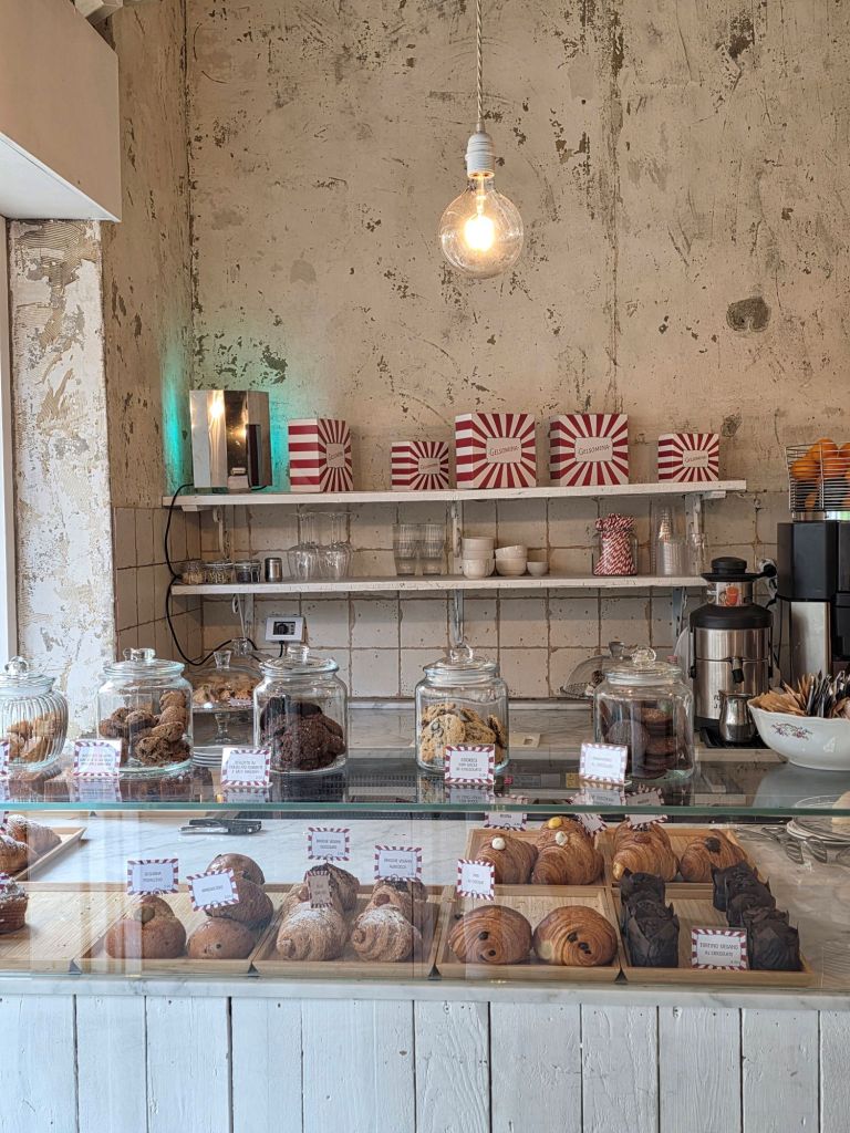 This blog post is about Gelsomina, a lovely hidden gem, located in Via Carlo Tenca 5, Milan. This photo features the main bar of the café displaying some of its specialties!