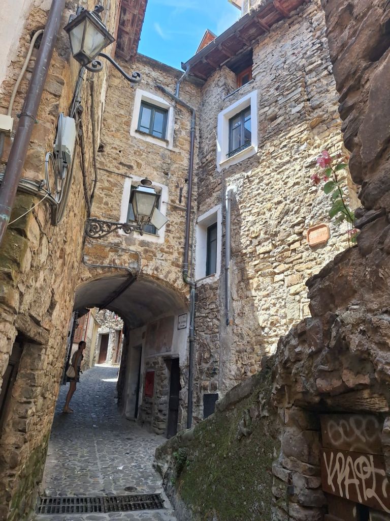 In this travel article I write about Apricale, a medieval, picturesque village nestled in the hills of the Nervia Valley, in the province of Imperia (Liguria). The photo shows a winding alley of Apricale.