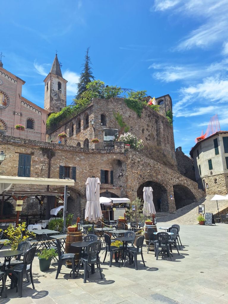 In this travel article I write about Apricale, a medieval, picturesque village nestled in the hills of the Nervia Valley, in the province of Imperia (Liguria). The photo shows a part of the main historical square called Piazza Torracca.