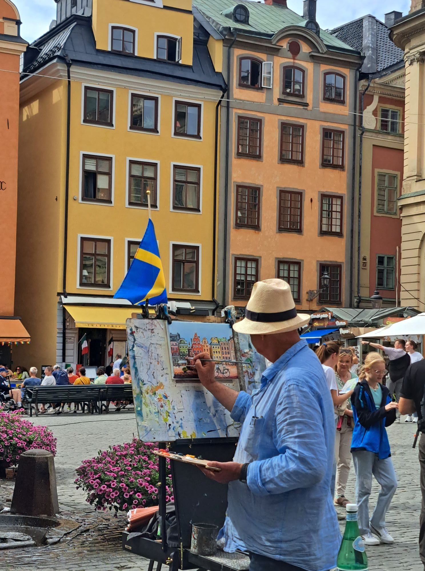 I'm Sofia Lena Perissinotto and I'm a travel blogger. In this blog post I write about Stockholm's old town, Gamla Stan, a lovely area of Stockholm centered on the island of Stadsholmen. This photo shows the main square: Stortorget with a street artist capturing the square's beauty.